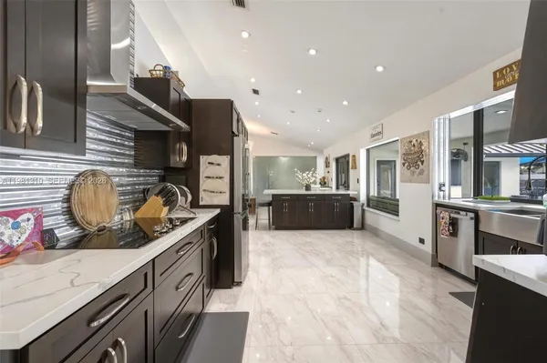 a kitchen with stainless steel appliances granite countertop a stove a sink and a refrigerator