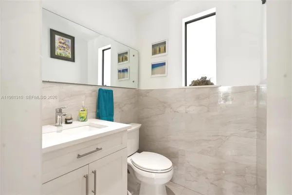 a bathroom with a sink mirror and toilet