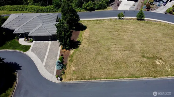 an aerial view of a house with a yard and lake view