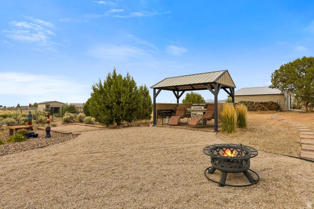 2925 Juniper Road Enterprise, UT 84725 - Photo 37 of 56 View of yard with a patio area and an outdoor fire pit