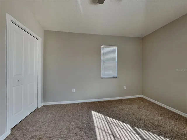 a view of a livingroom with a ceiling fan and window