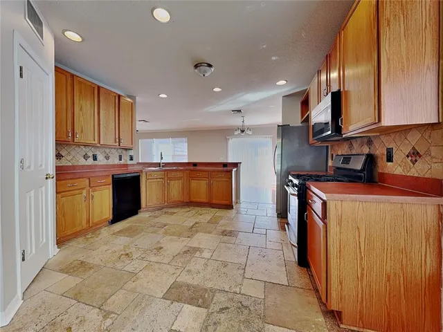 a kitchen with stainless steel appliances granite countertop a sink counter space cabinets and a large window