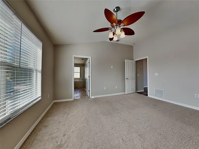a view of an empty room with a ceiling fan