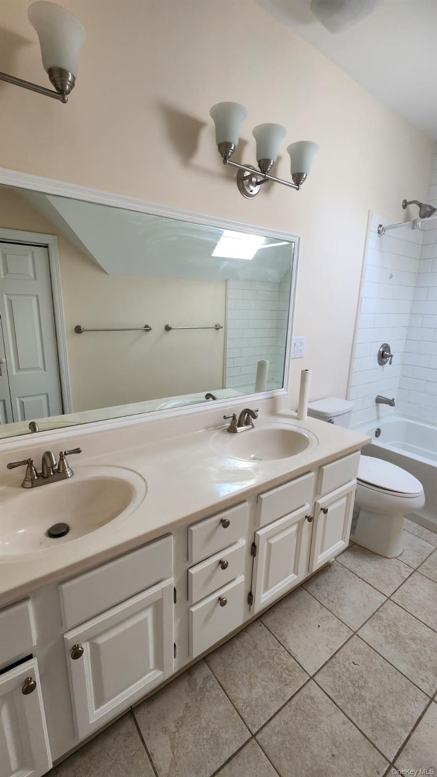92 Roe Avenue, Unit 3 Highland Falls, NY 10928 - Photo 13 of 17 Double vanity with integrated sinks, white cabinetry, and brushed nickel hardware; linen closet