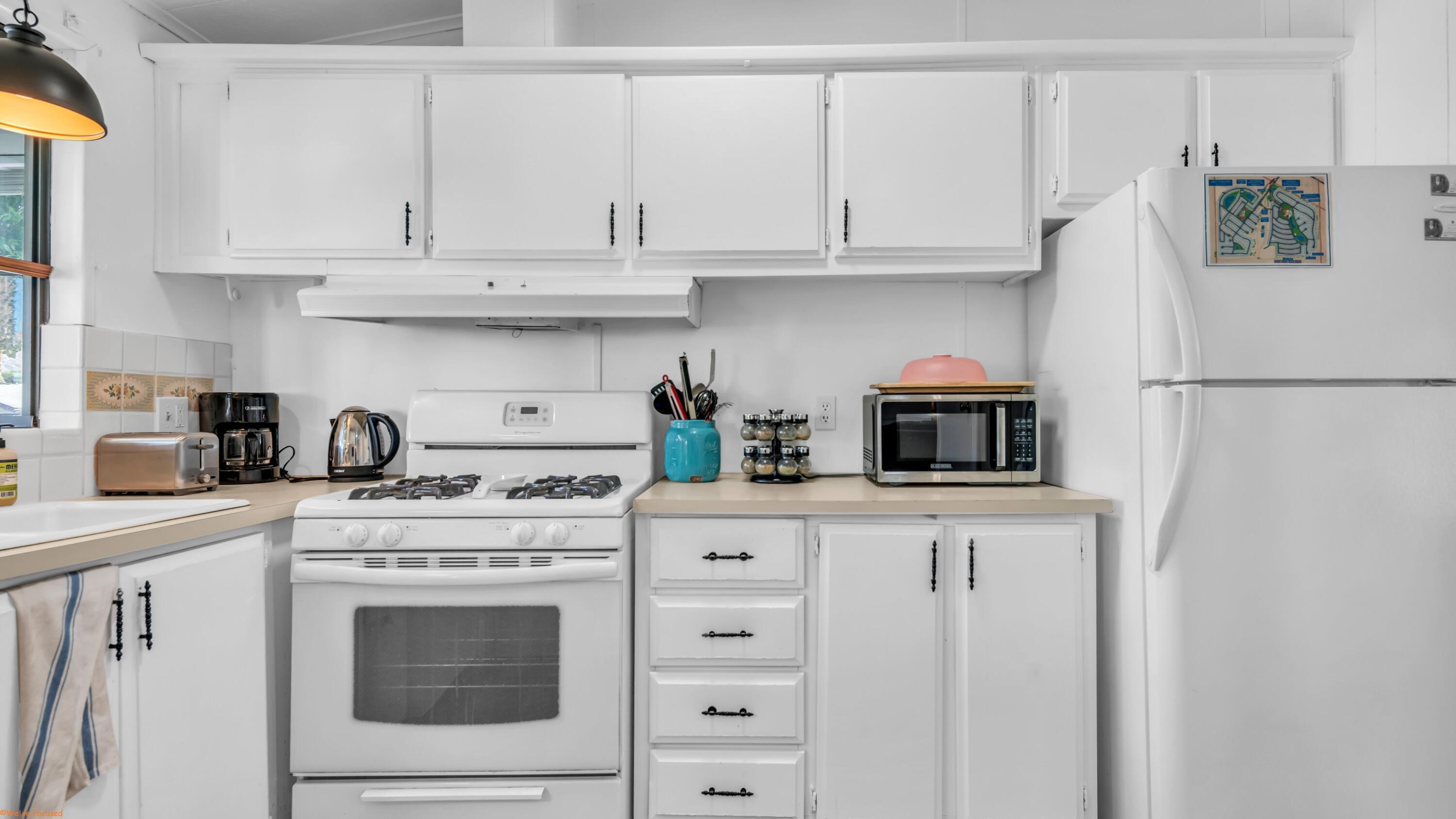 74711 Dillon Road, Unit 392 Desert Hot Springs, CA 92241 - Photo 9 of 46 a kitchen with stainless steel appliances granite countertop white cabinets sink and a refrigerator