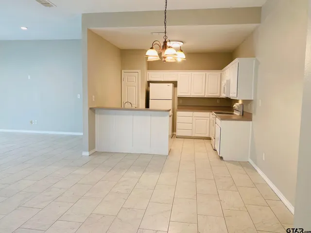 a kitchen with granite countertop a stove a sink and a refrigerator