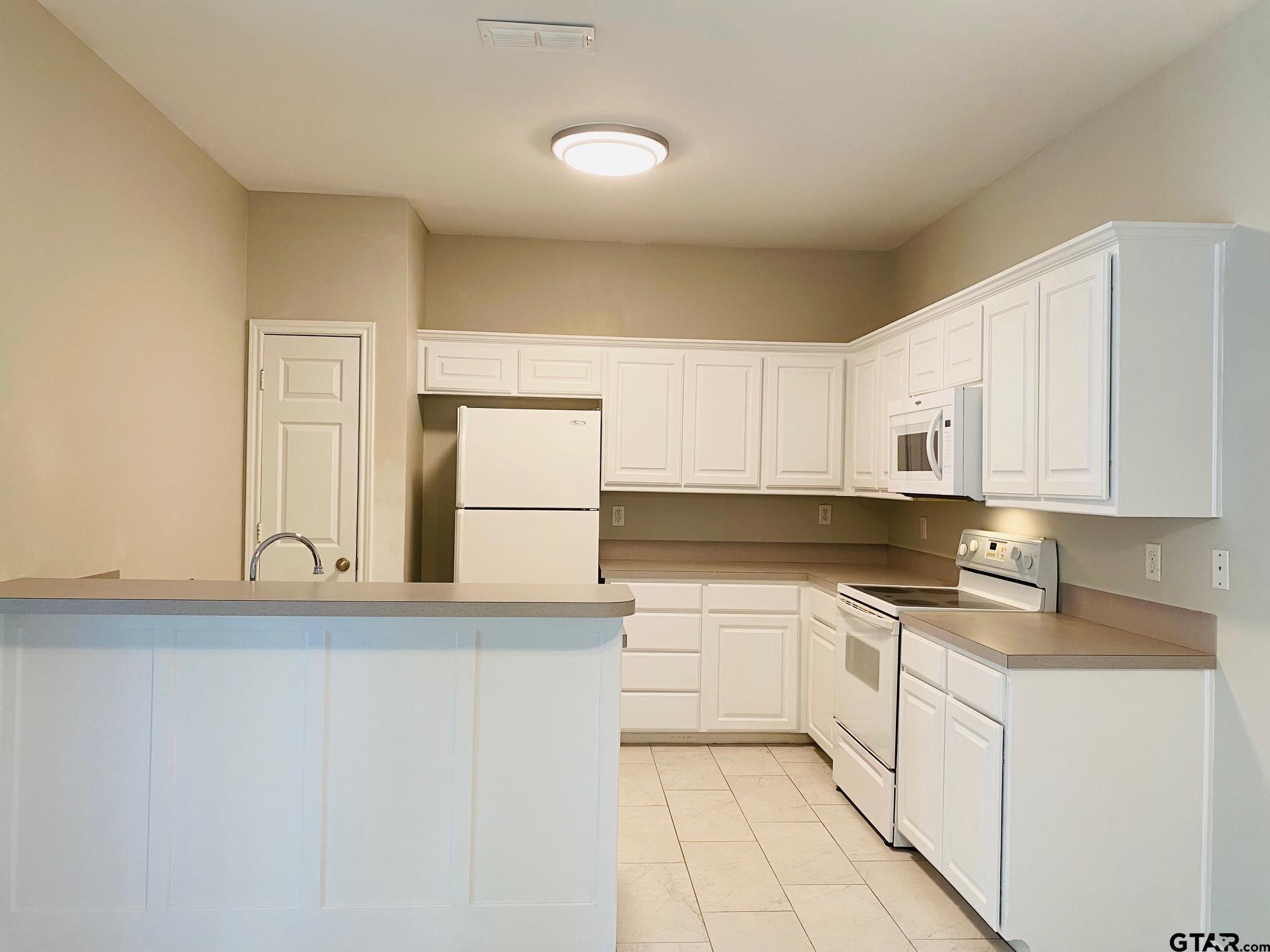 19586 FM 2493 Flint, TX 75762 - Photo 5 of 15 a kitchen with granite countertop white cabinets and white appliances