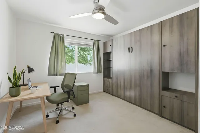 a view of a workspace with furniture and a window