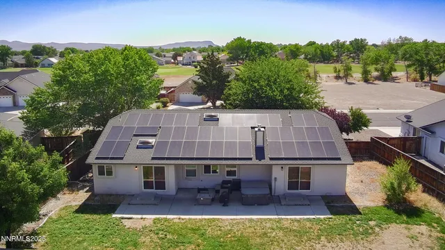 an aerial view of a house with table and chairs and a yard
