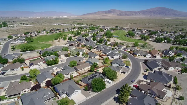 an aerial view of a city with lots of residential buildings and mountain view in back