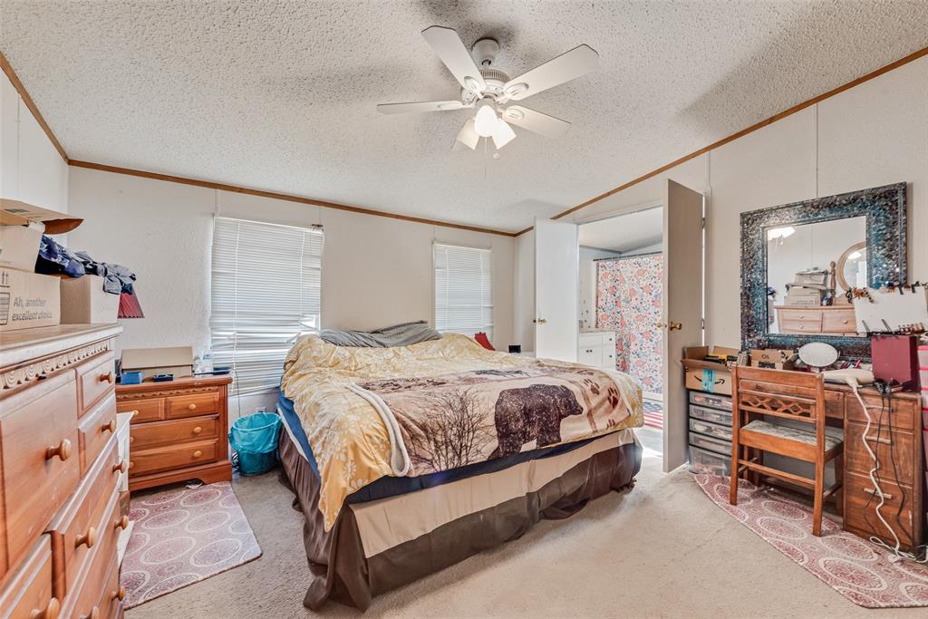 501 Billings Road Tolar, TX 76476 - Photo 13 of 22 a spacious bedroom with a bed and a chandelier