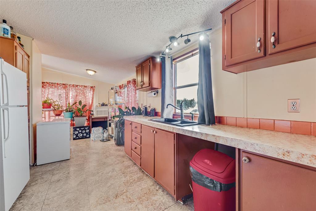 501 Billings Road Tolar, TX 76476 - Photo 6 of 22 a kitchen with stainless steel appliances granite countertop a refrigerator a sink dishwasher a dining table and chairs with wooden floor