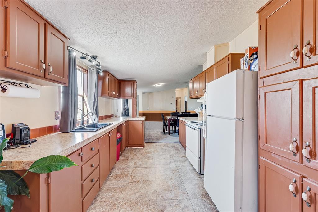 501 Billings Road Tolar, TX 76476 - Photo 7 of 22 a kitchen with stainless steel appliances a refrigerator a sink dishwasher with a dining table and chairs