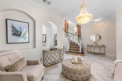 a living room with furniture and a chandelier