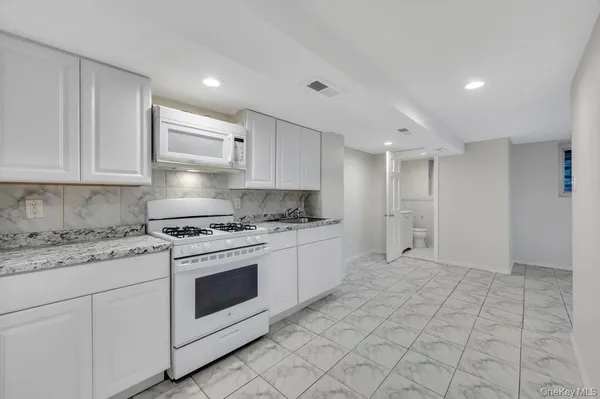 a kitchen with white cabinets and white appliances