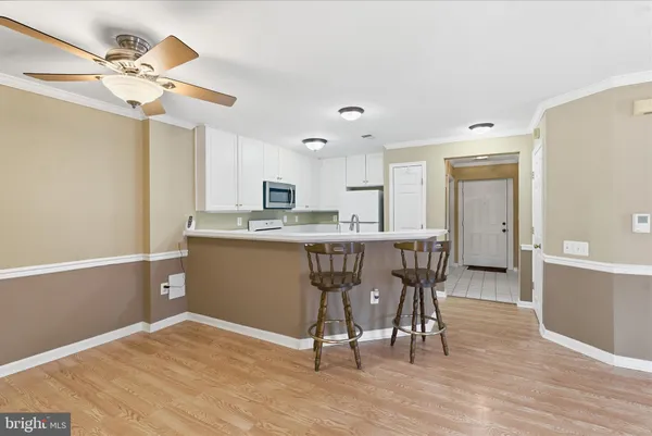a kitchen with stainless steel appliances kitchen island granite countertop a table chairs sink and cabinets
