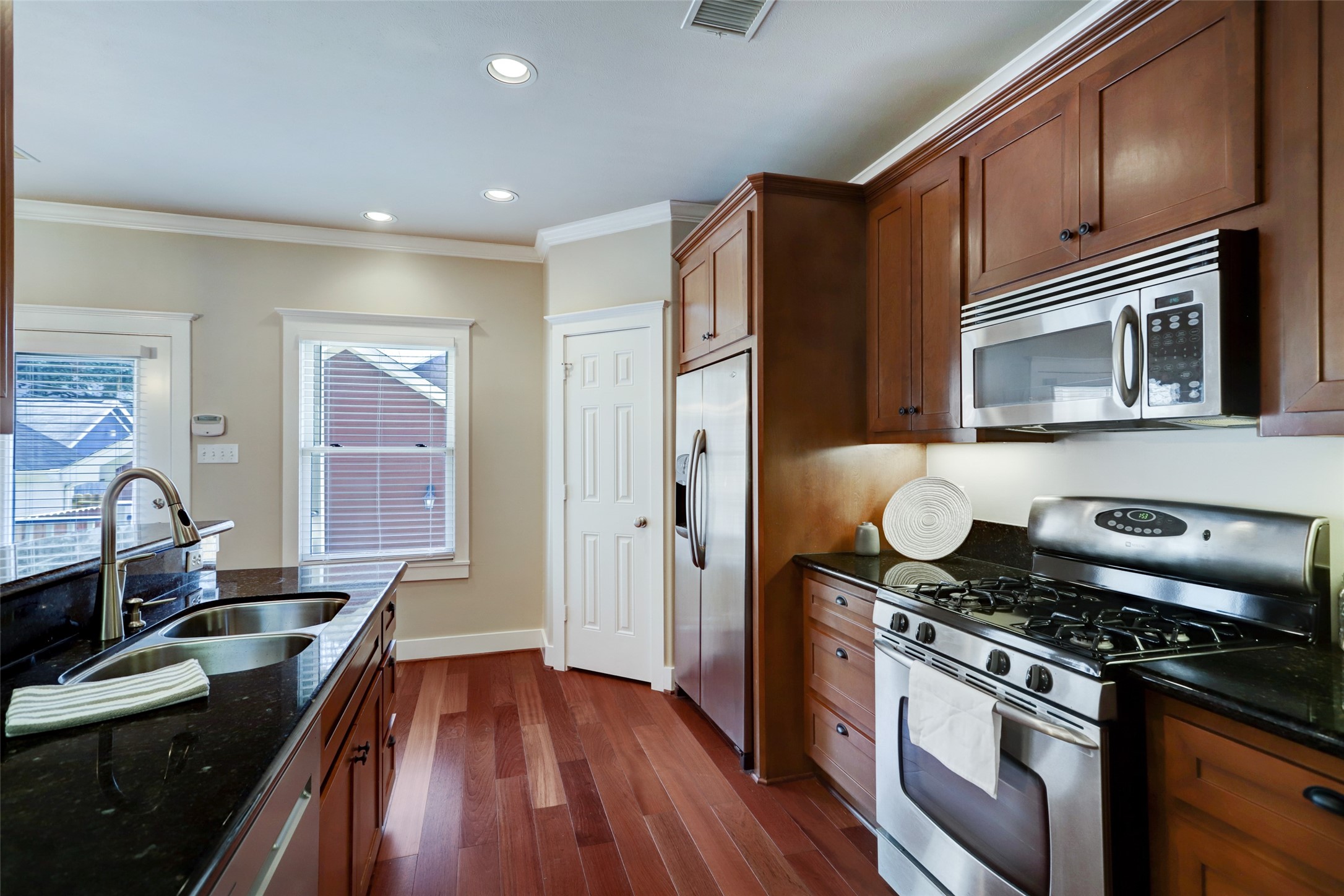 1047 West 16th Street Houston, TX 77008 - Photo 15 of 36 a kitchen with granite countertop cabinets stainless steel appliances and wooden floor