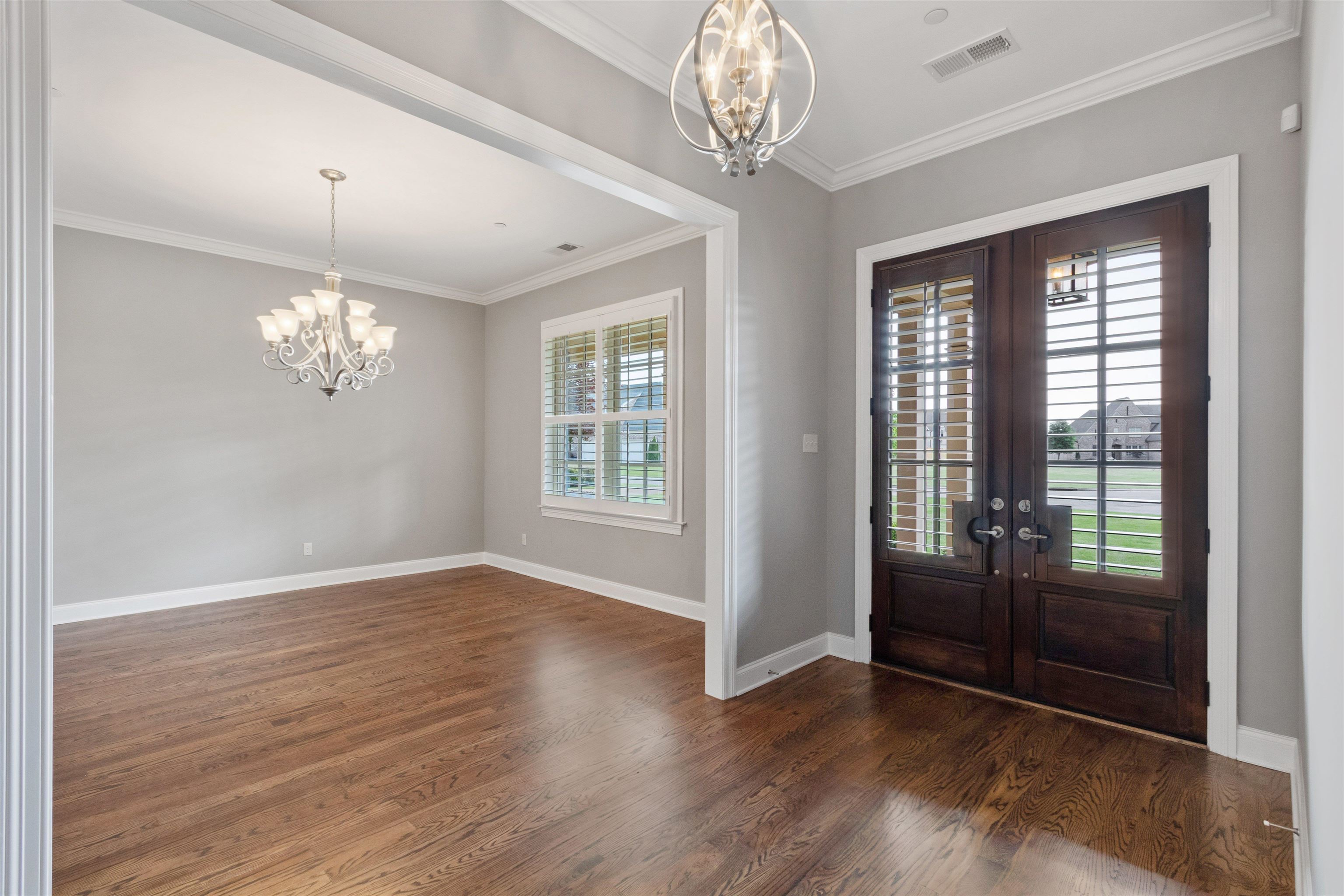 125 Hunters Rest Lane Piperton, TN 38017 - Photo 5 of 38 Foyer with hanging lights, crown molding, dark wood finished floors, and french doors