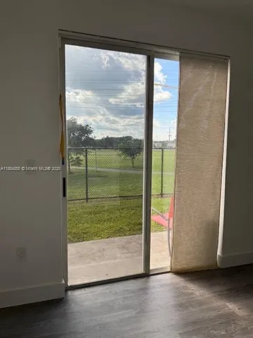 a view of a room with wooden floor and windows