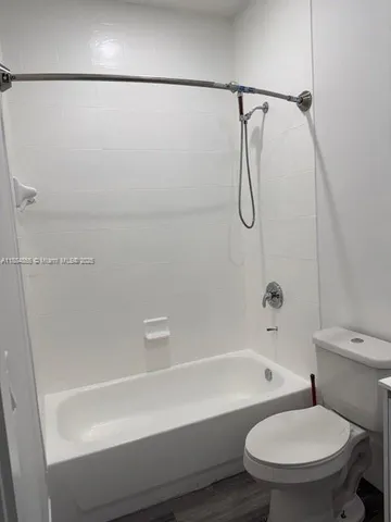 a bathroom with a toilet and a bath tub