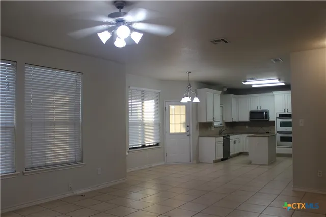 a large kitchen with a window and stainless steel appliances