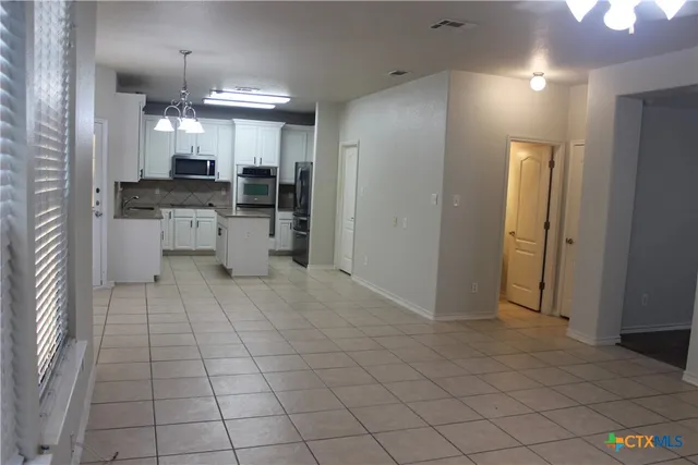 a kitchen with stainless steel appliances kitchen island granite countertop a refrigerator and a stove top oven