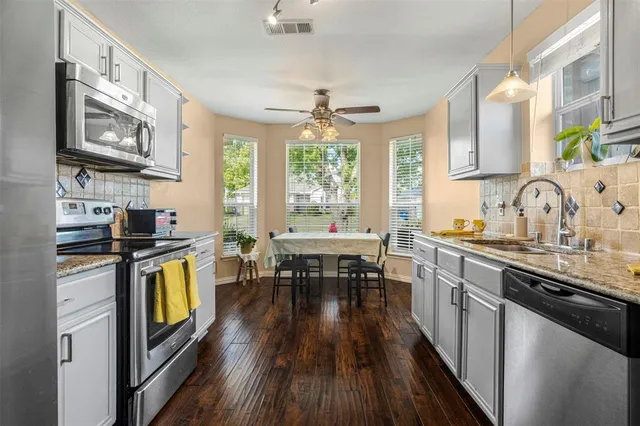 a kitchen with stove and wooden floor