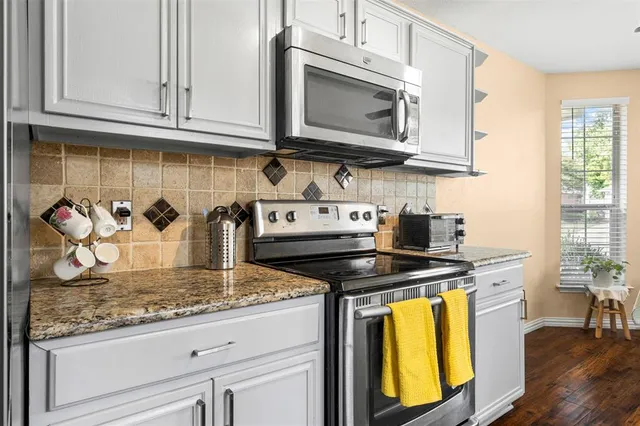 a kitchen with stainless steel appliances granite countertop a stove a microwave and cabinets