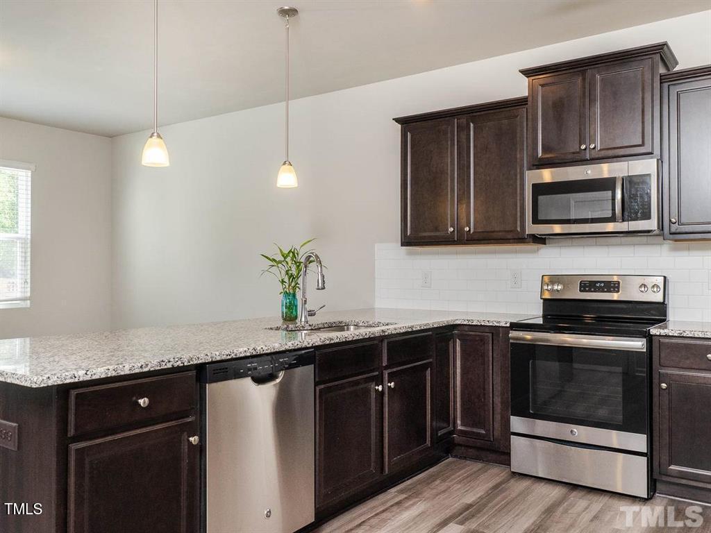 8862 Common Townes Drive Raleigh, NC 27616 - Photo 4 of 13 a kitchen with a sink stove and microwave