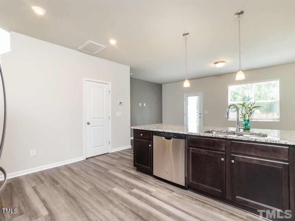 8862 Common Townes Drive Raleigh, NC 27616 - Photo 5 of 13 a kitchen with granite countertop a sink and cabinets