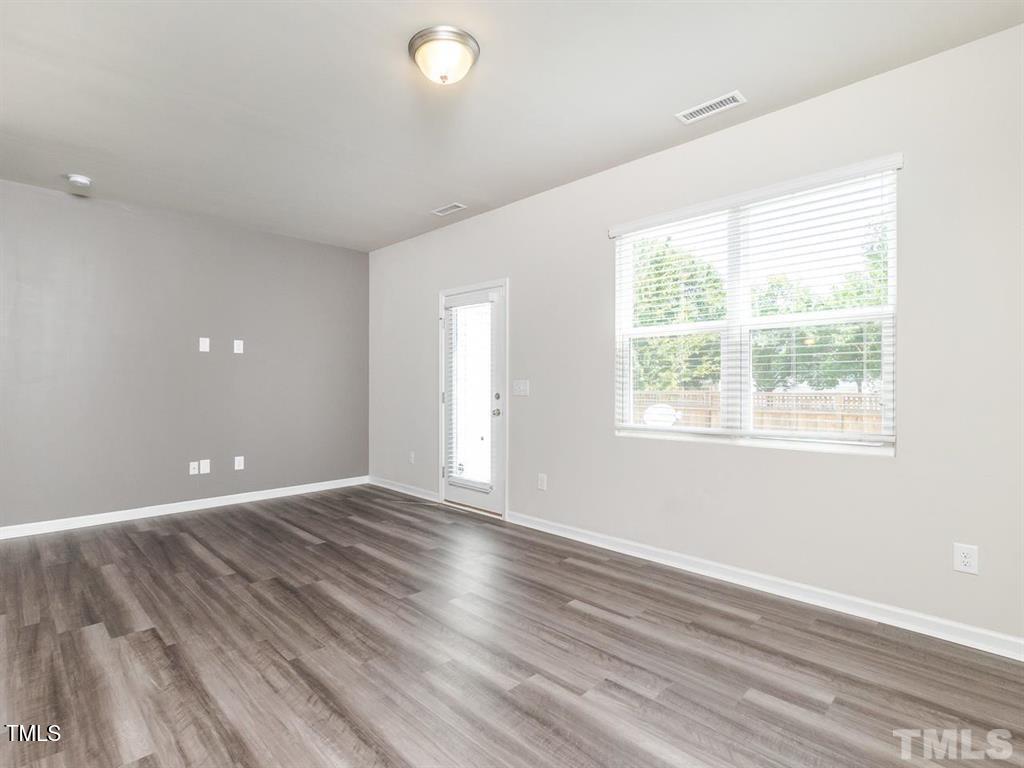 8862 Common Townes Drive Raleigh, NC 27616 - Photo 6 of 13 an empty room with wooden floor and windows