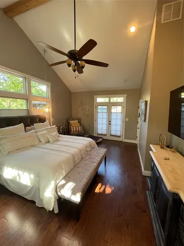 a spacious bedroom with a bed and wooden floor