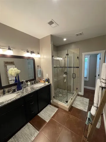 a bathroom with a shower sink and mirror