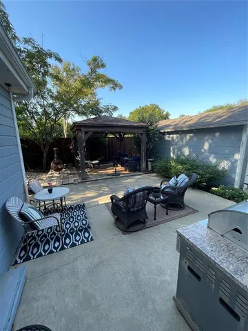 a view of a patio with couches and table and chairs under an umbrella