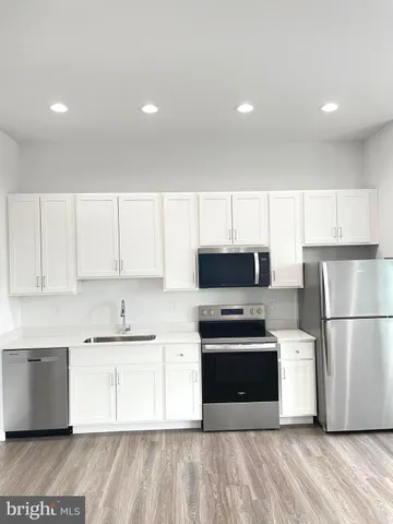 a kitchen with stainless steel appliances a refrigerator stove and microwave
