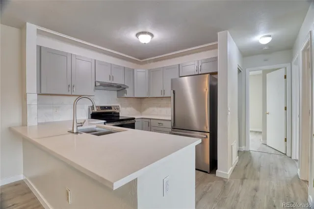 a kitchen with stainless steel appliances a refrigerator sink and cabinets