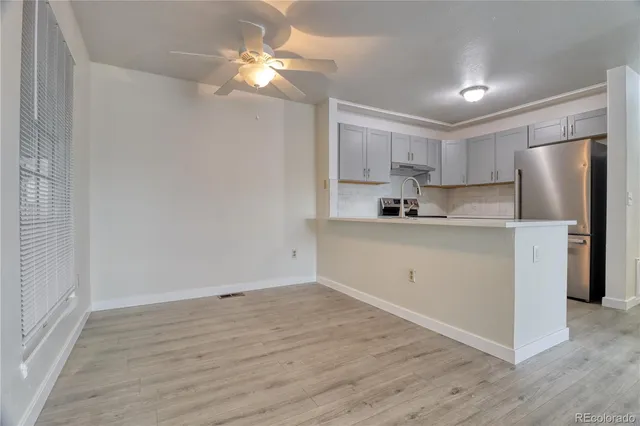 a kitchen with a refrigerator a sink and dishwasher with wooden floor
