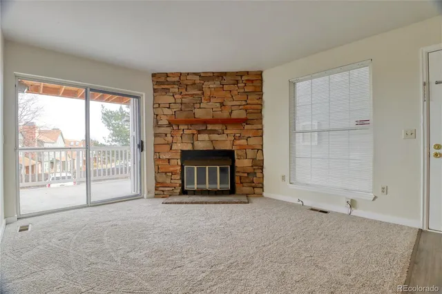 a view of an empty room with a fireplace and a window