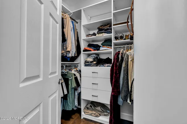 a view of walk in closet with clothes and shoes