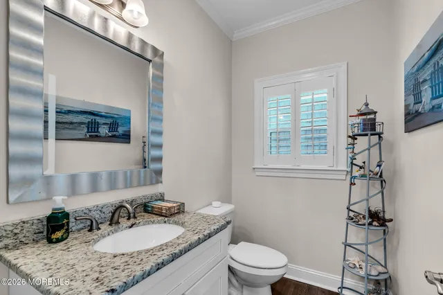 a bathroom with a granite countertop sink a toilet a mirror and shower