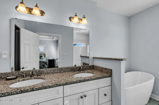 a bathroom with a granite countertop sink and a mirror