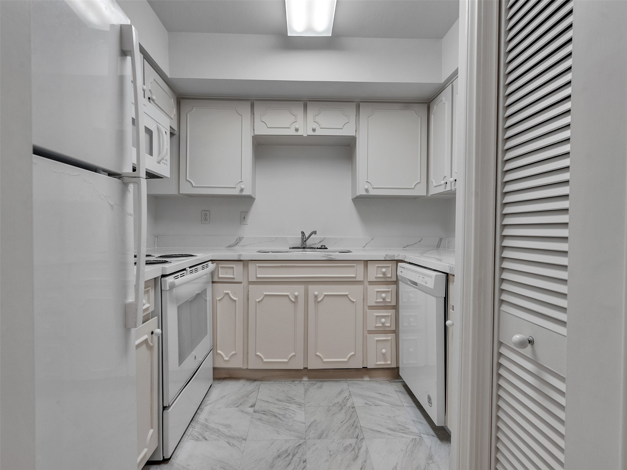5050 Ambassador Way, Unit 218 Houston, TX 77056 - Photo 8 of 15 Kitchen has a stackable washer/dryer and a refrigerator.