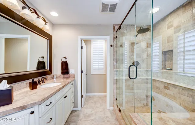a bathroom with a granite countertop sink and a large mirror