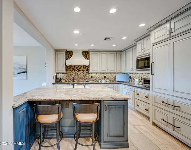 a kitchen with granite countertop kitchen island a table and chairs in it