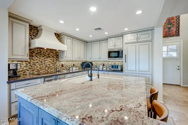a kitchen with granite countertop counter space dining table and stainless steel appliances