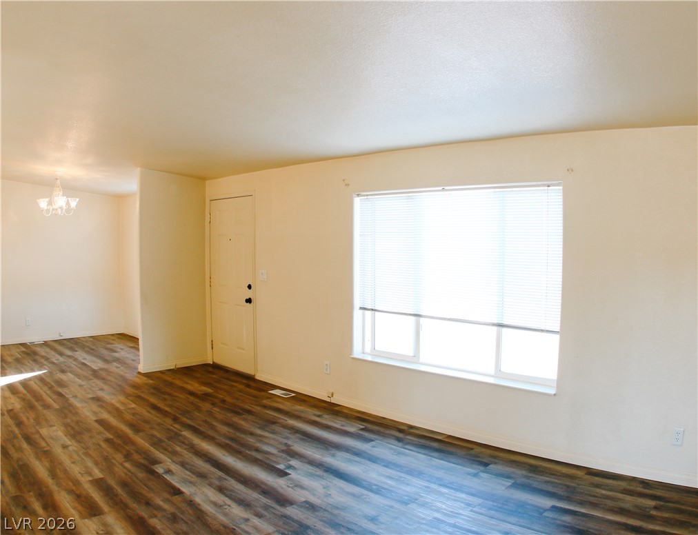 5231 Ruby Way Caliente, NV 89008 - Photo 18 of 35 Rich wood flooring stretches across this naturally illuminated living space, offering a harmonious blend of comfort and style.