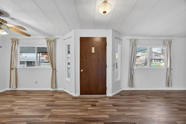 a view of a bedroom with wooden floor and windows