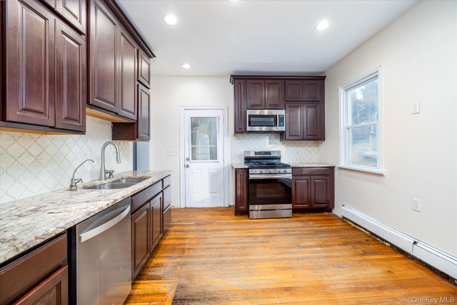 2483 Central Avenue Baldwin, NY 11510 - Photo 15 of 28 a kitchen with stainless steel appliances granite countertop a stove a sink and a refrigerator