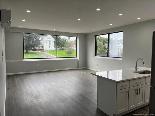 a kitchen with kitchen island granite countertop a stove and a sink