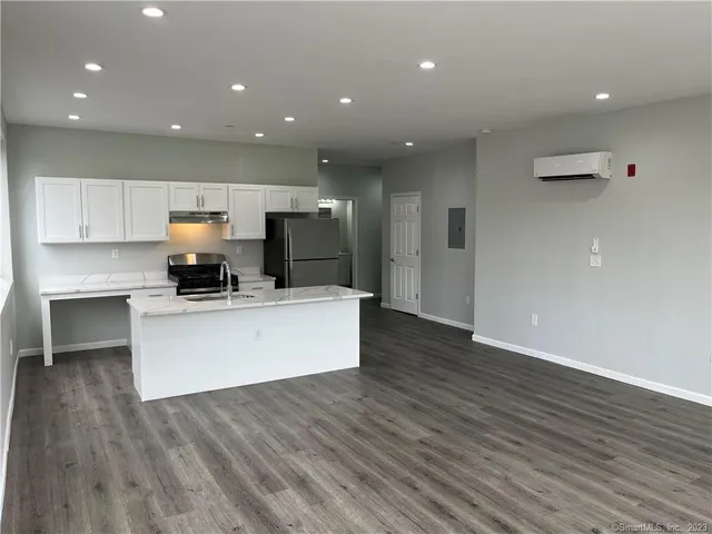 a view of kitchen with kitchen island microwave and cabinets
